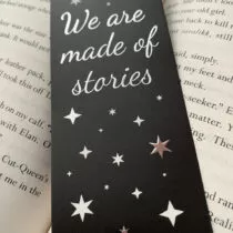 detailfoto zwarte boekenlegger met sterren en in het midden de tekst we are made of stories allemaal in zilver folie