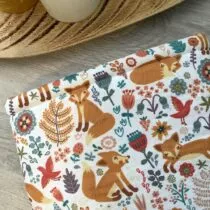 detailfoto van witte booksleeve met vosjes en verschillende kleuren bloemen