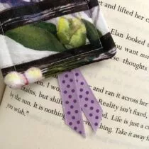 detailfoto van witte boekenlegger met zwarte strepen met daarop een grote bloem. Lintjes zijn paars met donkerpaarse stippen