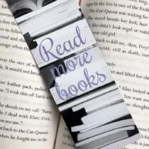 detailfoto van boekenlegger met zwart witte boeken met in het midden de tekst read more books