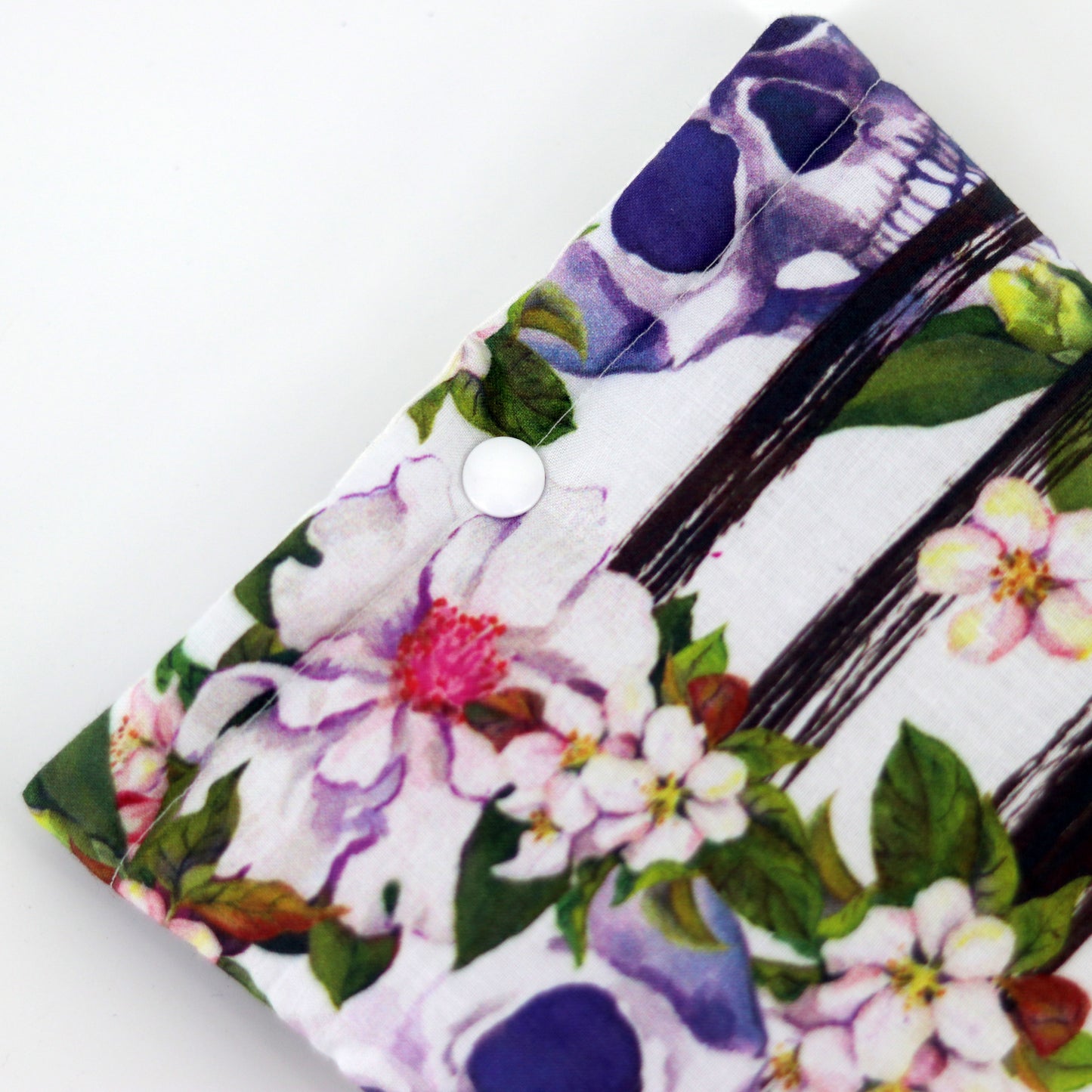 e-reader sleeve met witte achtergrond met daarop doodshoofden en bloemen